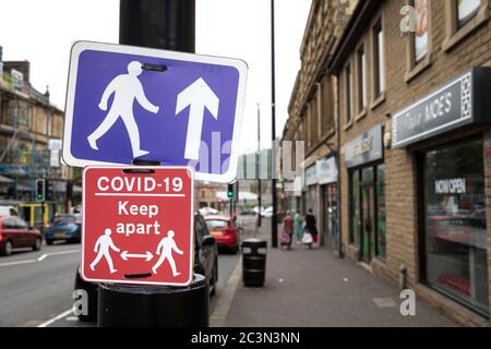 Schilder, die die Öffentlichkeit an die sozialen Distanzierungsanforderungen im Stadtzentrum von Keighley während der Coronavirus-Pandemie erinnern Stockfoto