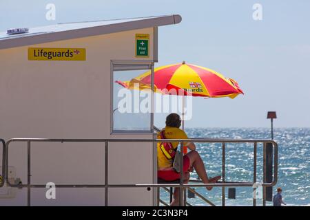 Bournemouth, Dorset, Großbritannien. Juni 2020. An einigen Stränden von Bournemouth sind RNLI-Rettungsschwimmer wieder im Einsatz, da die Temperaturen in der Woche für eine kleine Hitzewelle ansteigen, die Massen an die Strände locken wird. RNLI Lifeguard wacht an der Rettungsschwimmer-Kiosk-Hütte im Dienst. Quelle: Carolyn Jenkins/Alamy Live News Stockfoto