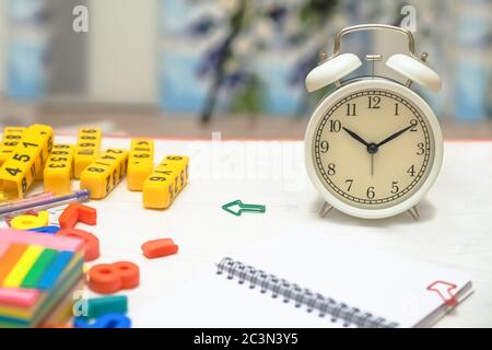 Kinder unterrichten. Kinderspielzeug in Form von Buchstaben, Zahlen und Wecker. Konzept zurück zur Schule, Hintergrund Stockfoto