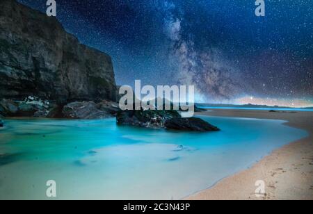 Felsen am Strand unter dem Nachthimmel voller Sterne Stockfoto