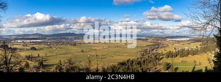 Panoramasicht auf die Landschaft mit Forggensee und Bannwaldsee von Schloss Neuschwanstein an einem sonnigen Wintertag mit blauer Himmelswolke in Backgroun Stockfoto