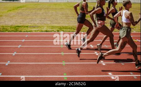 Weibliche Athleten Rennen auf der Strecke. Frauen im Rennen auf Leichtathletik Stadion Strecke. Stockfoto