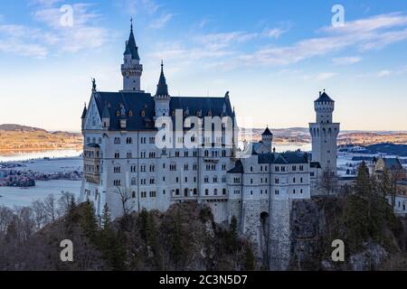 Herrlicher Blick auf das berühmte Schloss Neuschwanstein am Wintermorgen, mit herrlichem Sonnenschein und dem Forggensee im Hintergrund, Schwangau, Bayern Stockfoto