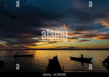 Silhouette von kleinen traditionellen Booten und Touristen in der Abenddämmerung in der Albufera in Valencia, einer Süßwasserlagune und Mündung in Ostspanien. Stockfoto