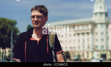 Mann, der im Hof der Stadt steht. Porträt des jungen Mannes in lässiger Kleidung stehen. Stockfoto