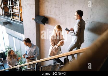 Eine Gruppe von Geschäftsleuten, die in einem Bürogebäude Treppen gehen und gehen Stockfoto