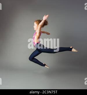 Junge akrobatische Mädchen erschossen beim Springen im Studio Stockfoto