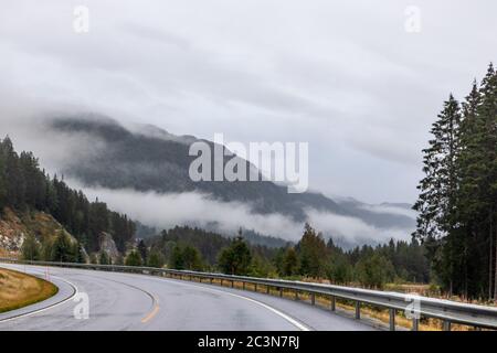 Autobahn in einem nebligen Gebirge von Norwegen. Herbst malerischer Nebel niedrige Wolken auf dem Weg nach Oslo an einem regnerischen nassen Morgen Stockfoto