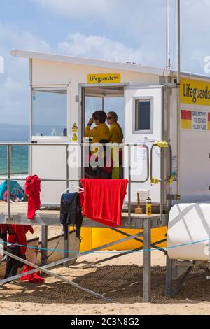 Bournemouth, Dorset, Großbritannien. Juni 2020. An einigen Stränden von Bournemouth sind RNLI-Rettungsschwimmer wieder im Einsatz, da die Temperaturen in der Woche für eine kleine Hitzewelle ansteigen, die Massen an die Strände locken wird. RNLI-Rettungsschwimmer wachen an der diensthabenden Rettungsschwimmer-Kiosk-Hütte. Quelle: Carolyn Jenkins/Alamy Live News Stockfoto