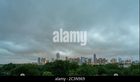 Weitwinkelansicht der Skyline von Downtown Austin in den frühen Morgenstunden mit großem Lichtsturm am Himmel Stockfoto