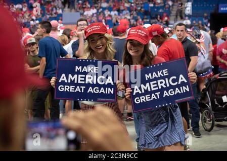 TULSA, Oklahoma, USA. - 20. Juni 2020: Zwei weibliche Trump-Unterstützerin hält ein Zeichen, als eine Fotografin ihr Foto macht. Stockfoto