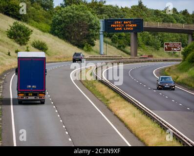 Verkehr auf A1 mit neuer Pandemiemeldung Covid-19 auf der Gantry „Stay Safe Protect Others Save Lives“, East Lothian, Schottland, Großbritannien Stockfoto