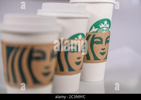 Starbucks Tassen - Starbucks Trinkbecher - Starbucks Takeway Tassen - Starbucks Take Away Tassen auf einem weißen hellen Tisch Stockfoto