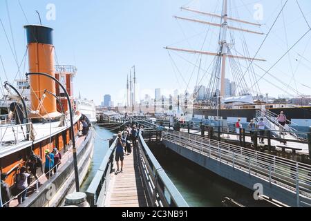 An einem sonnigen Tag in San Francisco, Kalifornien, USA, besuchen die Menschen historische Schiffe im San Francisco Maritime National Historical Park Stockfoto