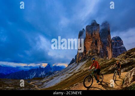 Radfahren Outdoor-Abenteuer in den Dolomiten. Radfahren Frau und Mann auf Elektro-Mountainbikes in der Dolomitenlandschaft. Paar Radfahren MTB Enduro Trac Stockfoto