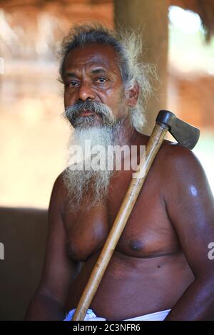 "Menschen im Wald" - Ethnischer Stamm Vedda in Sri Lanka. Aborigines Jäger mit Axt und Bogen. Portrait des Stammesoberhaupt Stockfoto