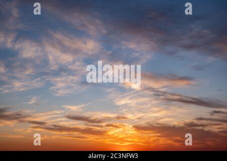 Sonnenuntergang orange Wolkenlandschaft Hintergrund. Dramatischer magischer Sonnenaufgang über orange bewölktem Himmel. Dämmerung, Dämmerung Stockfoto