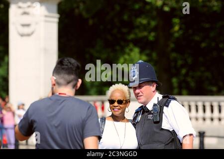 London, Großbritannien - 23. JULI 2016: Touristen fotografieren mit dem Londoner Metropolitan Polizist
