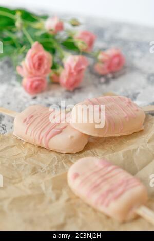 Gourmet-Eis Dessert Kokosnuss-gewürzt Eisschokolade Glasur rosa Schokolade aus einer Bäckerei zu Hause auf grauem Hintergrund. Selektiver Fokus, Kopierbereich. Stockfoto