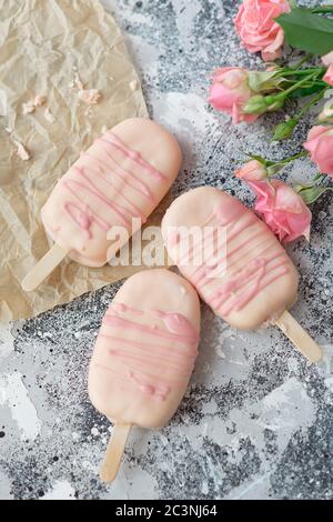 Gourmet-Eis Dessert Kokosnuss-gewürzt Eisschokolade Glasur rosa Schokolade aus einer Bäckerei zu Hause auf grauem Hintergrund. Selektiver Fokus, Kopierbereich. Stockfoto