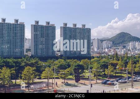 Busan, Südkorea 15. September 2019: Blick von oben auf einen Teil des APEC Naru Parks und modernes Stadtbild mit Hügeln und blauem Himmel im Hintergrund Stockfoto