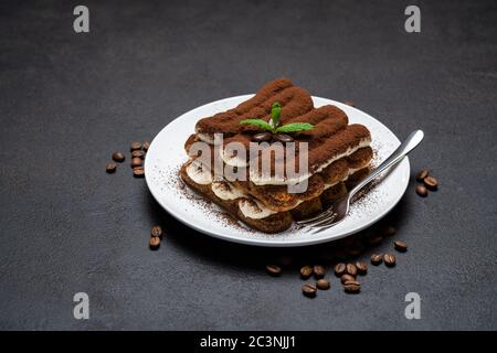 Klassisches Tiramisu Dessert auf Keramikplatte auf Betongrund Stockfoto