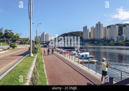 Busan, Südkorea 15. September 2019: Fahrradweg mit Radfahrern und Mann beim Training in der Nähe des Kanals an sonnigen Tagen Stockfoto