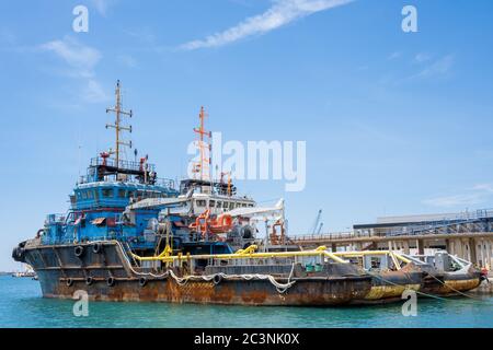 Versorgungsbehälter der Plattform. Rostige Fähren mit Kräne im Hafen. Malaga, Spanien - 01. Juni 2020. Stockfoto