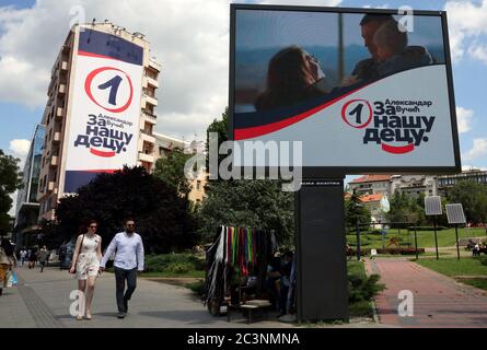 Das Paar hält die Hände, wenn es an den Plakaten der regierenden Serbischen Fortschrittspartei (SNS) des amtierenden Präsidenten Aleksandar Vucic ahea vorbeikommt Stockfoto