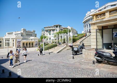 Biarritz, Frankreich - 17. Juni 2018: Bürgersteig, Straße zur Promenade, Spaziergänger, Casino-Gebäude, sonniger Sommertag Stockfoto