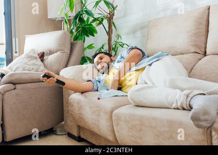 Foto eines gutaussehenden hispanischen Mannes, der auf einem Sofa liegt Und Fernsehen Stockfoto