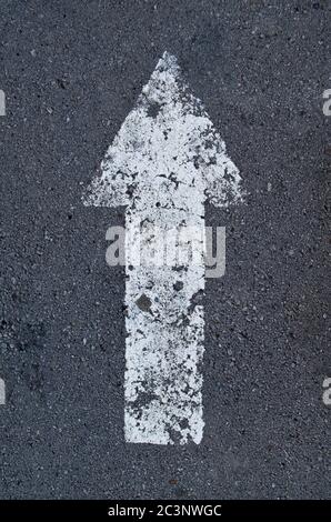 Zeiger Pfeil auf dem Asphalt, weiß verblasste Farbe. Stockfoto