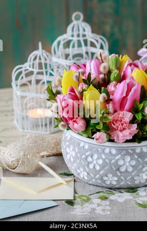 Floristin bei der Arbeit: Frau zeigt, wie man schöne Blumenarrangement mit Tulpe und Nelkenblumen zu machen. Ostern Heimtextilien. Schritt für Schritt, Tutorial Stockfoto