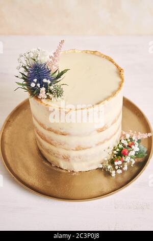 Vertikale Aufnahme eines schönen und leckeren Kuchen mit Blume Und goldene Ränder auf weißem Hintergrund Stockfoto
