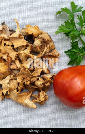 Trockene Pilze, Tomaten und Grüns auf einer Leinwandserviette. Gesundes Esskonzept Stockfoto