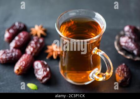 Türkischer Tee und getrocknete Datteln auf schwarzem Hintergrund Nahaufnahme Stockfoto