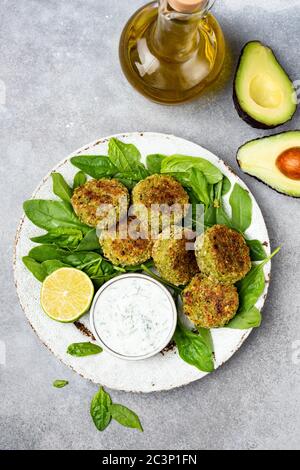 Falafel mit Tsatziki-Sauce, Avocado- und Spinatsalat. Gesunde vegetarische Speisen Stockfoto