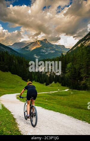 Touristisches Radfahren in Cortina d'Ampezzo, atemberaubende felsige Berge im Hintergrund. Frau auf dem MTB Enduro Flow Trail. Südtirol Provinz Italien, D Stockfoto