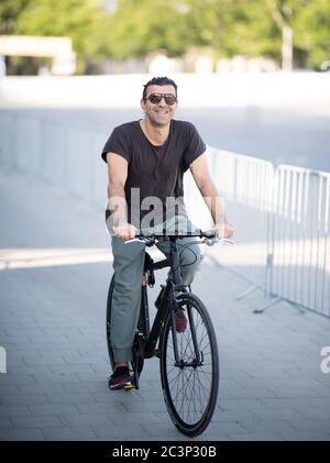 Hamburg, Deutschland. Juni 2020. Regisseur Fatih Akin kommt mit dem Fahrrad zum Einfahrkino auf dem Heiligengeistfeld zur Vorführung seines Films 'Tschick'. Quelle: Daniel Reinhardt/dpa/Alamy Live News Stockfoto