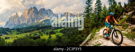 Touristisches Radfahren in Cortina d'Ampezzo, atemberaubende felsige Berge im Hintergrund. Mann beim MTB Enduro Flow Trail. Südtirol Provinz Italien, Dol Stockfoto