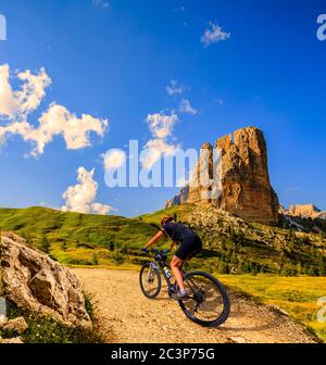 Touristisches Radfahren in Cortina d'Ampezzo, atemberaubende felsige Berge im Hintergrund. Frau auf dem MTB Enduro Flow Trail. Südtirol Provinz Italien, D Stockfoto