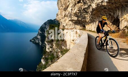 Radler auf dem Fahrrad auf Sonnenaufgangsbergen und Garda See Landschaft. Radfahren MTB Enduro Flow sentiero ponale Trail Track. Outdoor-Sport. Stockfoto