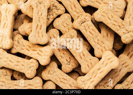 Haufen von Knochen geformten Hundekekse der braunen Farbe. Abstrakte Tapete. Stockfoto