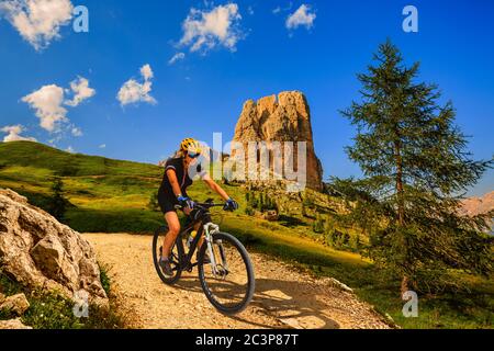 Touristisches Radfahren in Cortina d'Ampezzo, atemberaubende felsige Berge im Hintergrund. Frau auf dem MTB Enduro Flow Trail. Südtirol Provinz Italien, D Stockfoto