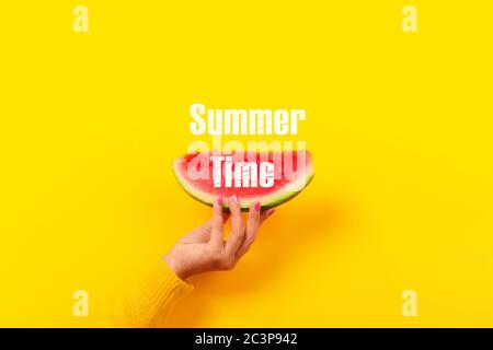 Hand hält Wassermelone Schicht über gelben Hintergrund. Sommer Konzept. Stockfoto