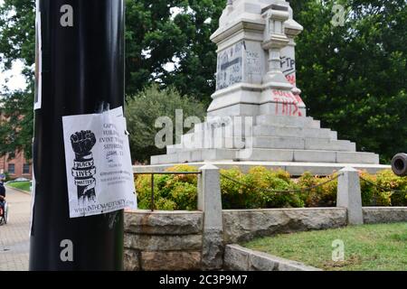 Raleigh, NC, USA 20. Juni 2020 - Nahaufnahme eines Flyers der Schwarzen Leben, der an einen Mast vor der mit Graffiti bedeckten Basis des Confederate Civil war Monument vor dem Old Capitol Building geklebt ist. Nach wochenlangen Protesten, die durch die Tötung von George Floyd durch die Polizei ausgelöst wurden, gelingt es den Demonstranten am 75. Juni, zwei Figuren von der 1,2 Meter hohen Säule abzuziehen, und am nächsten Morgen befahl der Gouverneur von NC, sie und zwei andere konföderierte Denkmäler zu entfernen. Stockfoto