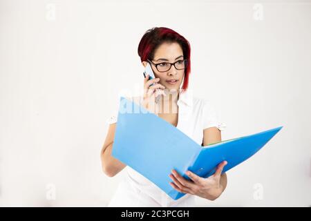 Nahaufnahme einer rothaarigen Frau, die per Telefon und nimmt Einen Ordner halten Stockfoto