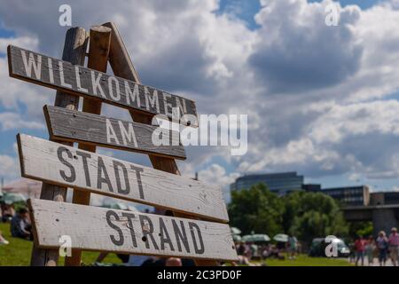 Willkommen in City's Beach Side, und unverschämtes Hintergrundleben von Menschen sitzen und hängen im Park am Flussufer des Flusses. Stockfoto