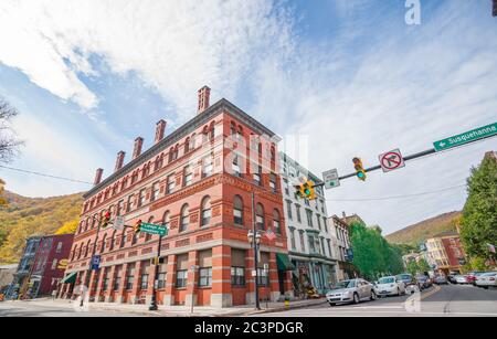 Jim Thorpe USA - Oktober 21 2014; Straßenkreuzung in einer kleinen Stadt mit einem atemberaubenden Beispiel der Architektur des roten Backsteins. Stockfoto