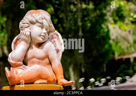 Ein Cherub sitzt auf einem Brunnen im Garten des Fontaine of Youth Archaeological Park in Ponce de Leon in St. Augustine, Florida. Stockfoto